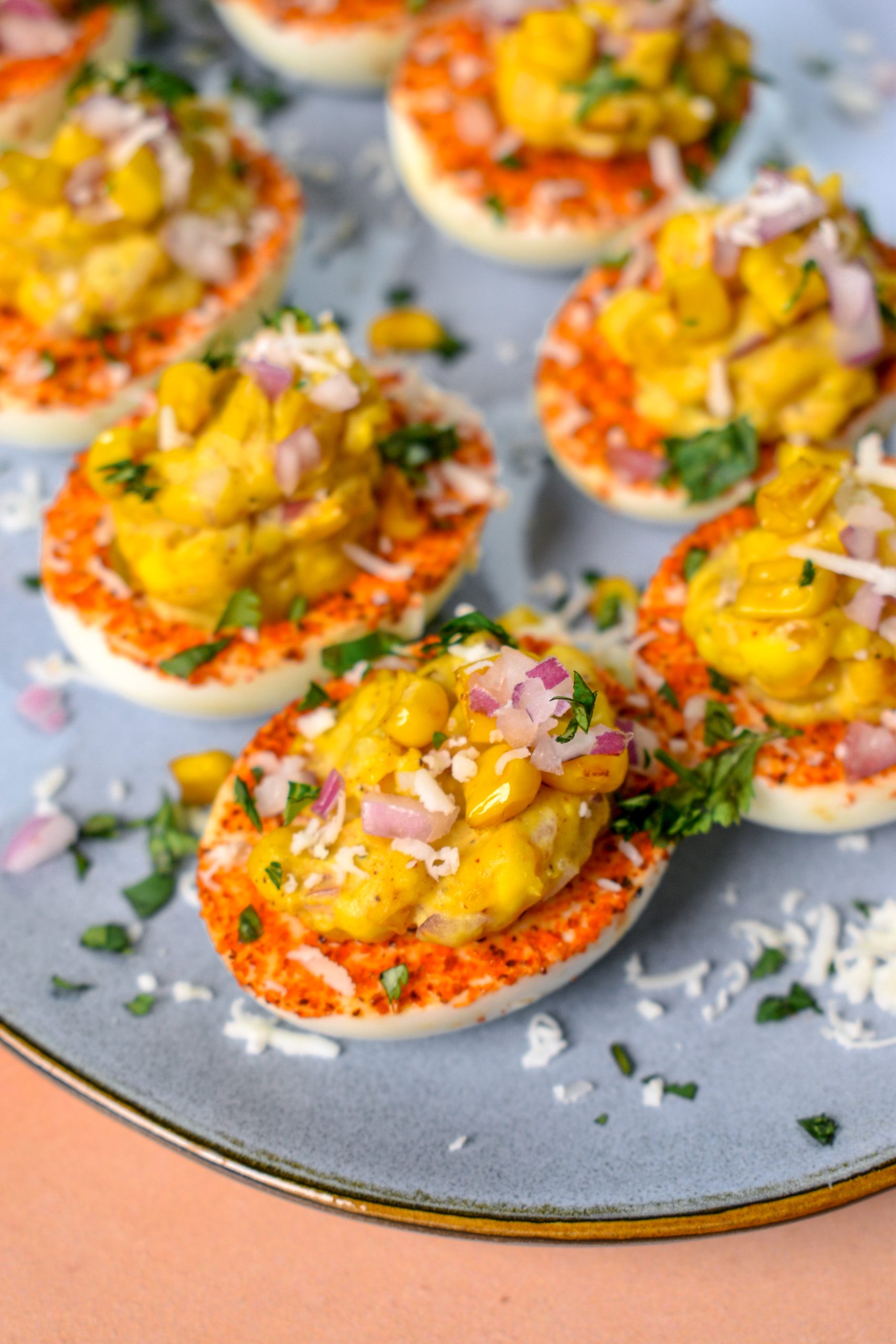 This is an image of elote deviled eggs on a blue plate
