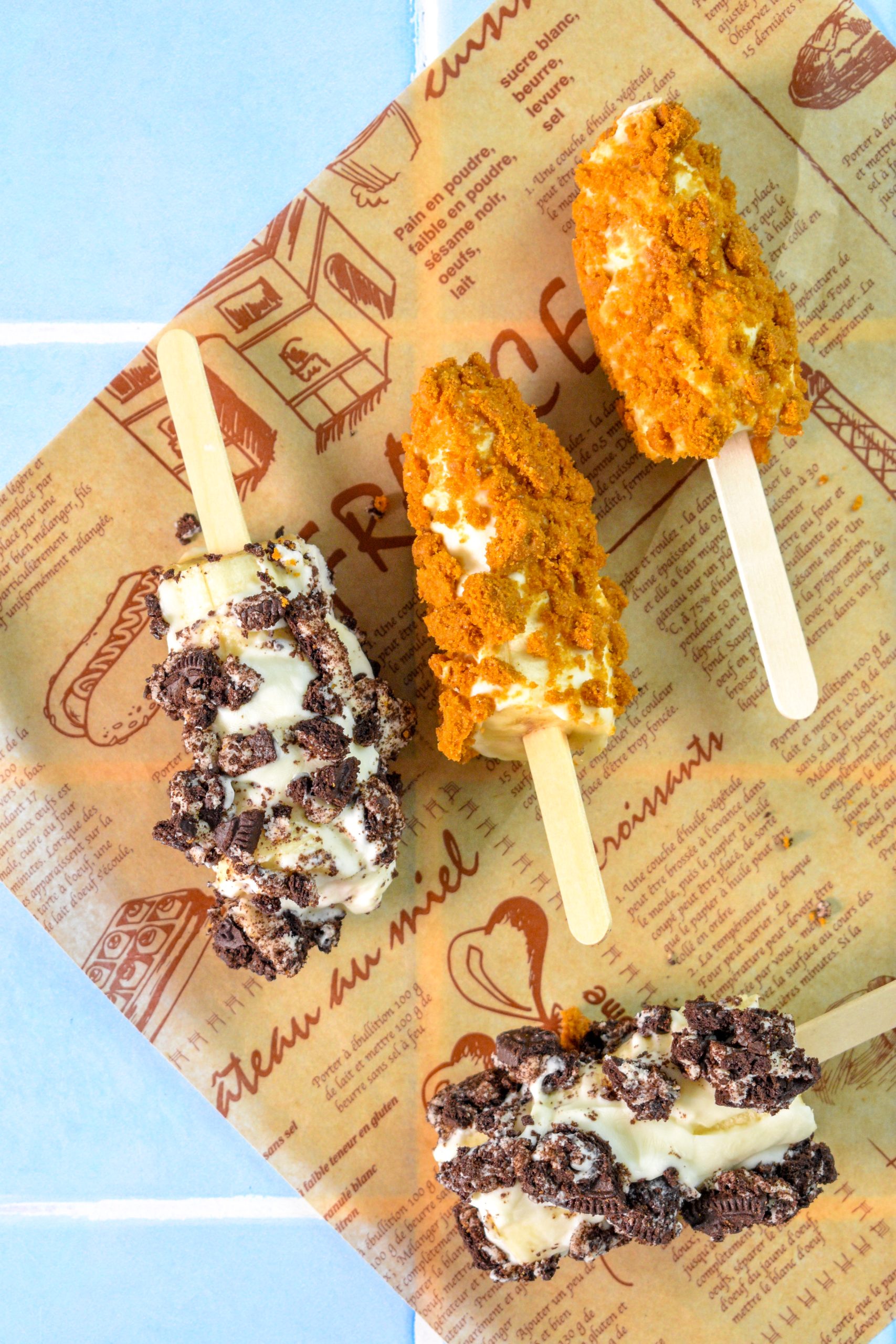 This is an image of frozen banana pops sitting on parchment paper